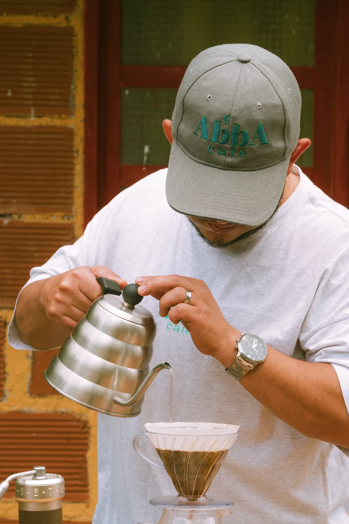 Alejandro García preparando un V60 con la gorra bordada de Abba Café